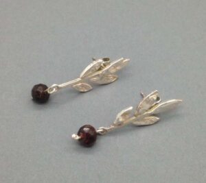 4 leaf stud with faceted garnet (54).   Jewellery by Holly Belsher. Silver & garnet.