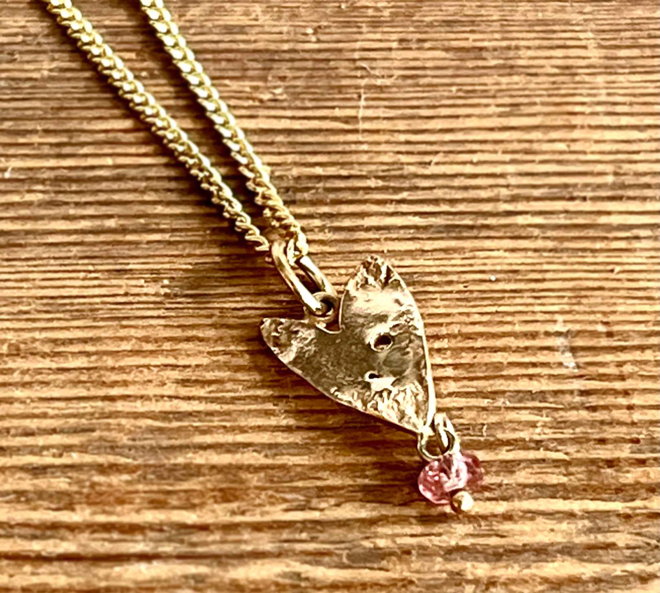 9ct gold sharp heart with pink tourmaline and 40cm chain (10).   Jewellery by Holly Belsher. 9ct gold & tourmaline.
